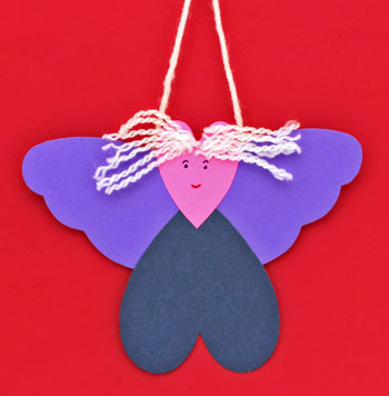 Heart Angel Ornament finished and hanging against a red background