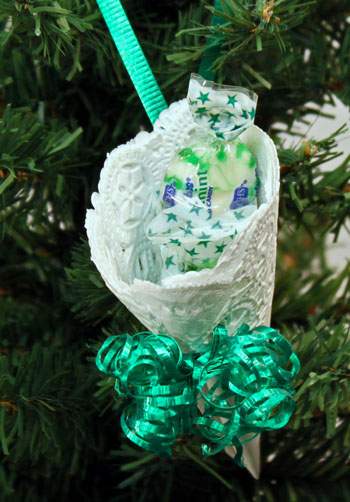Easy Christmas Crafts Paper Doily Cone Ornament finished with green ribbon hanging on tree