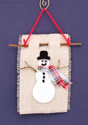 Easy Christmas Crafts Felt and Twig Snowman finished and hanging on a wall