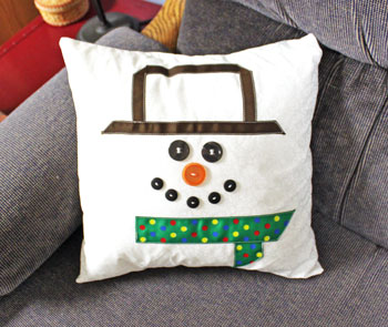 Fred the Snowman Pillow finished on couch to the left