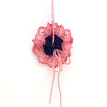 Lace and Seam Binding Flower Ornament pink and blue on display