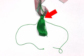 Ribbon and Bell Tassel Ornament step 12 secure with 24 inch yarn