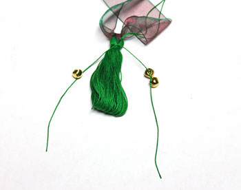 Ribbon and Bell Tassel Ornament step 14 thread bells on yarn ends