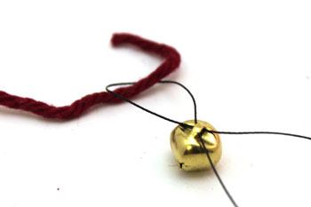 No Sew Felt Bell Ornament step 2 thread yarn through bells