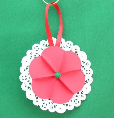 Paper Circles Triangle Doily Ornament in red handing on display